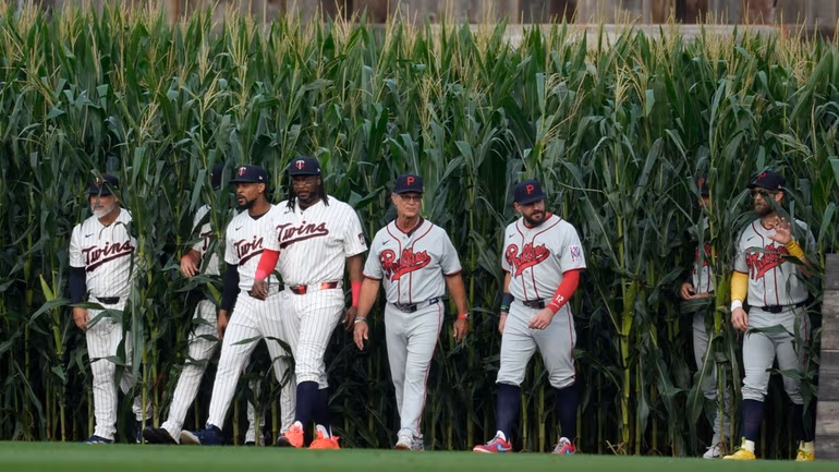 Players walk onto the field before a baseball game between the Minnesota Twins and the Philadelphia Phillies at the Field of Dreams movie site, Thursday, Aug. 13, 2026, in Dyersville, Iowa. Credit: AP/Charlie Neibergall